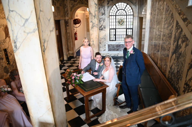 bride - groom and witnesses signing the register. 