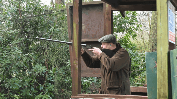 A male client having a go at clay pigeon shooting on a corporate day in Manchester   