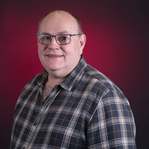 Male corporate headshot shot on a red background